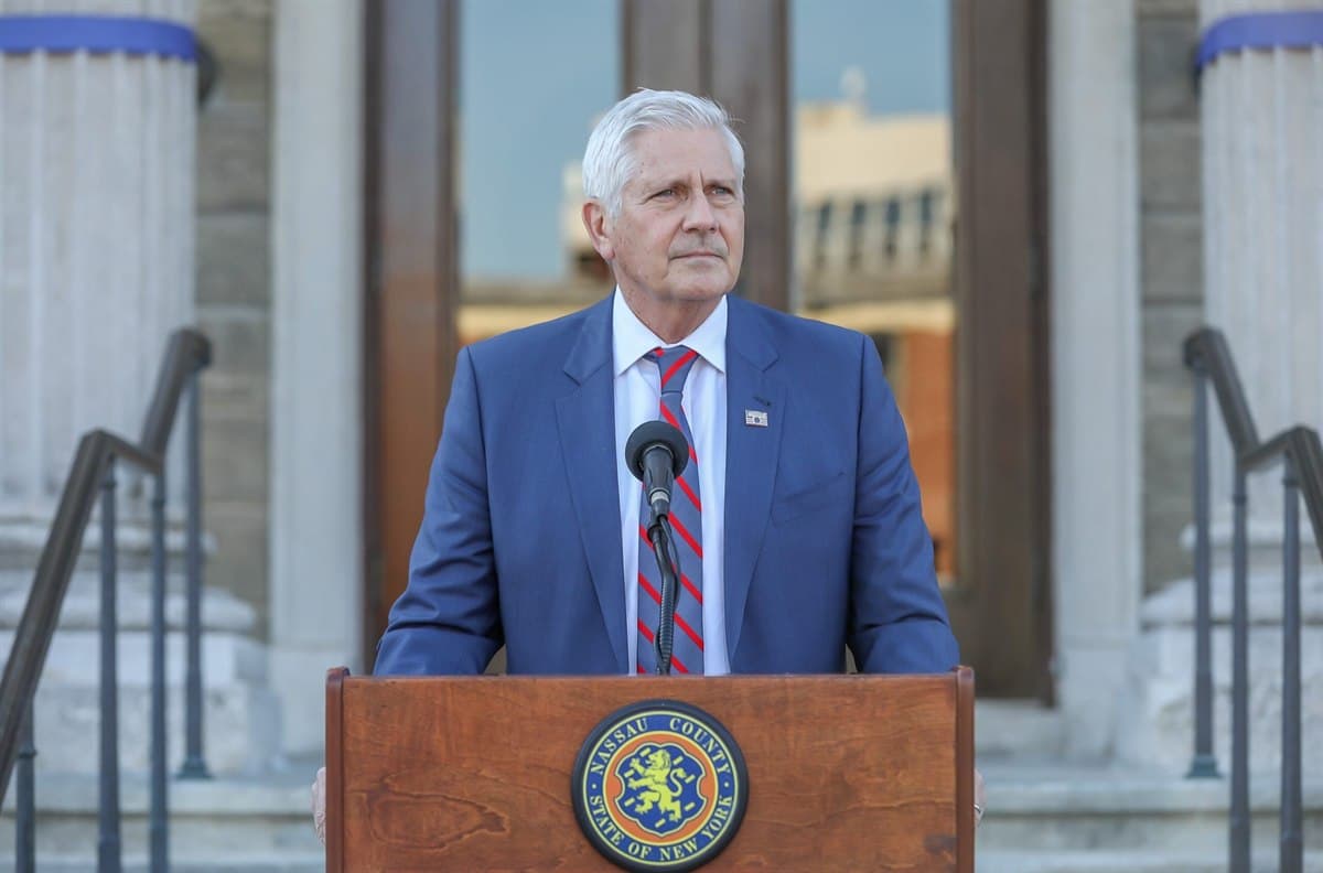 Bruce Blakeman standing at a lectern bearing the seal of Nassau County, State of New York.