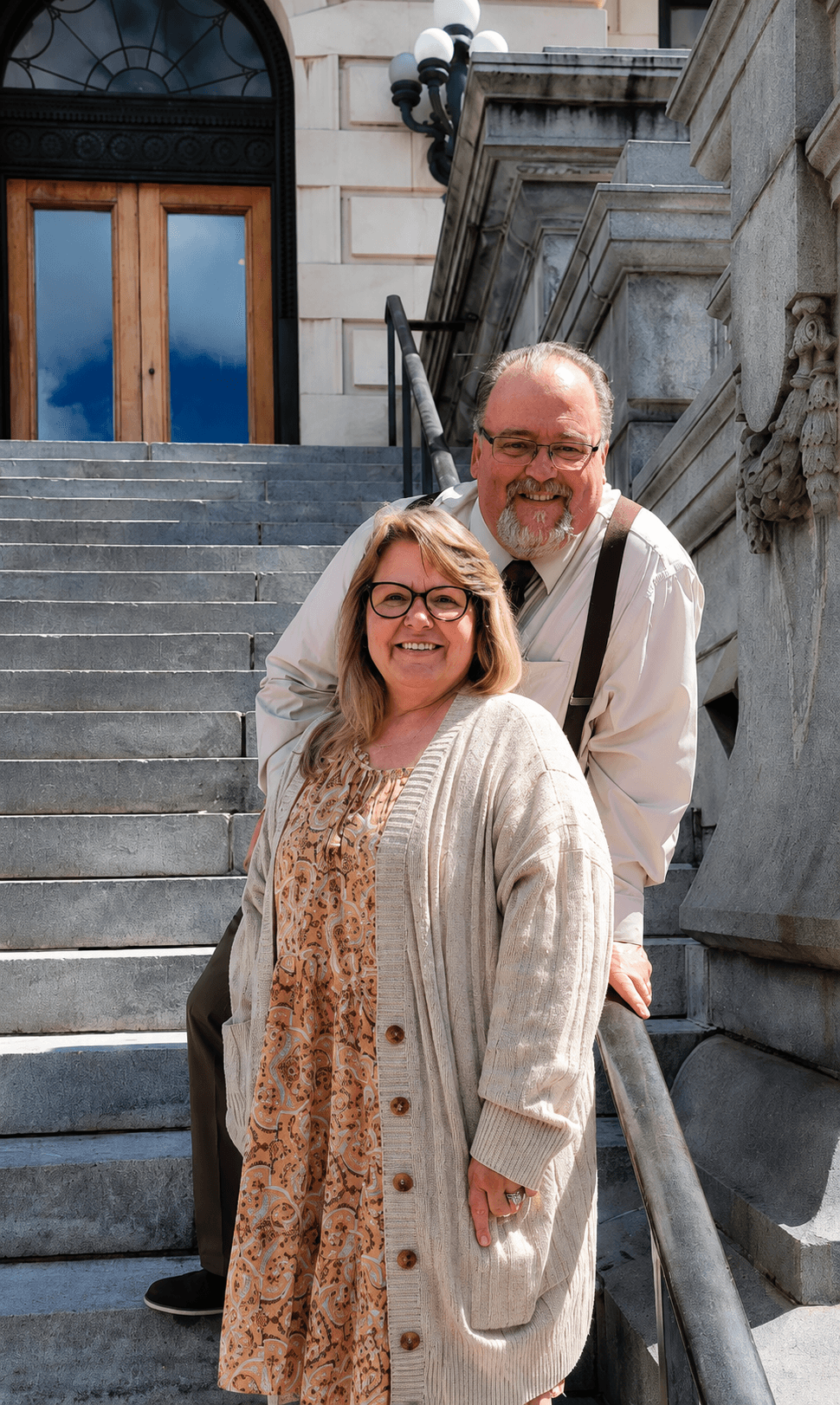 Nancy and Scott White, standing together on the steps of a courthouse.